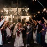 Wedding couple walking from ship as people hold sparklers